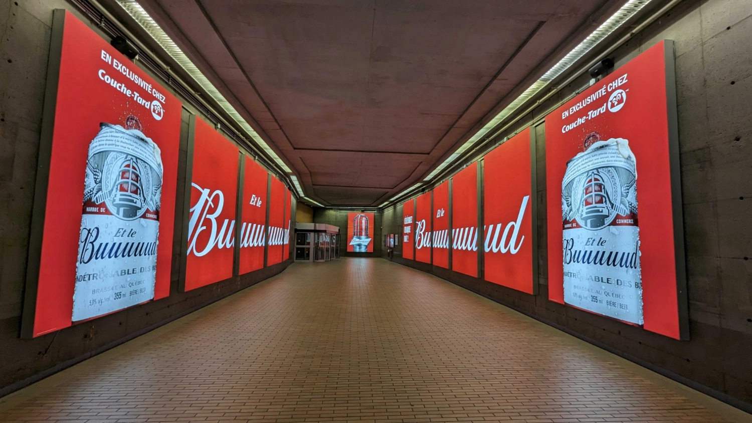 Large-format SEG lightbox installation featuring a Budweiser advertising campaign in a high-traffic underground corridor in downtown Montreal.